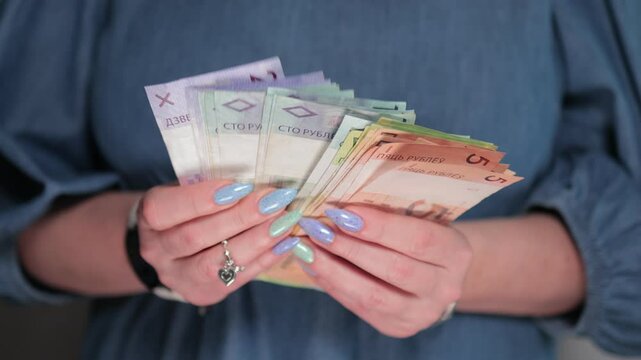 Female hands holding paper bills Belarusian rubles