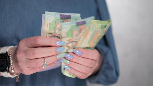 Female hands holding paper bills Belarusian rubles