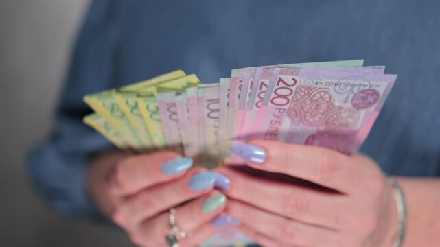Female hands holding paper bills Belarusian rubles
