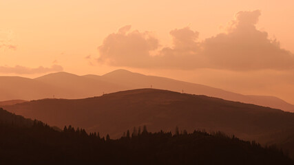 Orange sunset with the setting sun behind the mountains