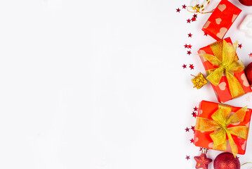 Red and gold christmas baubles, red gift boxes at white background. Merry Christmas greeting card,