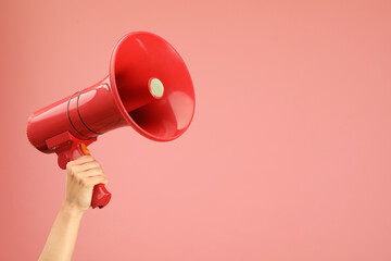 Woman holding megaphone speaker on pink background, closeup. Space for text