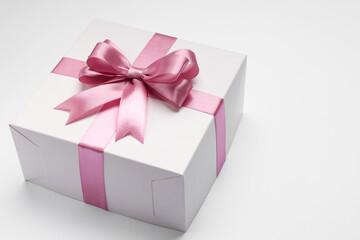 Gift box with pink bow on light grey background. Space for text