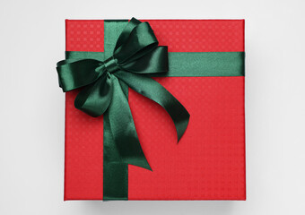 Gift box with green bow on light grey background, top view