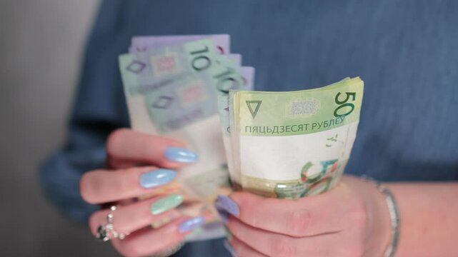 Female hands holding paper bills Belarusian rubles