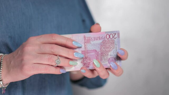 Female hands holding paper bills Belarusian rubles