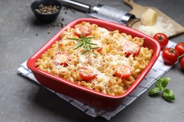 Delicious al forno pasta in baking dish on grey table