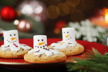 Funny marshmallow snowmen and cookies on table, closeup