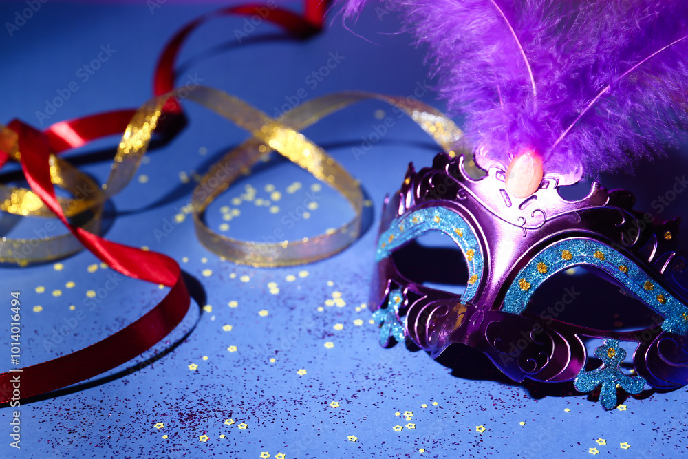 Canvas Prints Beautiful bright carnival mask, ribbons and confetti on blue background, closeup