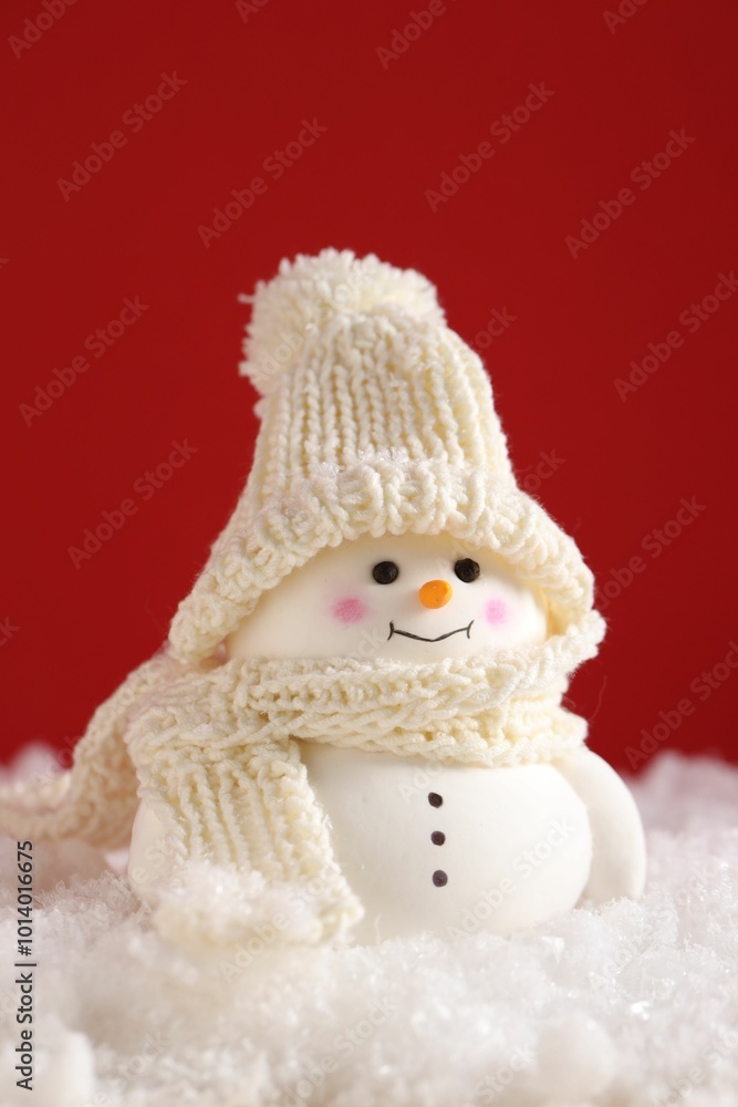 Canvas Prints Cute decorative snowman on artificial snow against red background