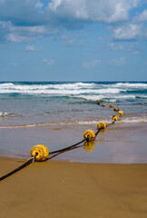 A rope with buoys to mark a safety zone on a sandy beach on the Mediterranean coast in Jaffa-Tel...