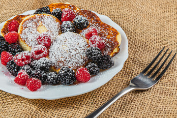 Cottage cheese pancakes with fresh raspberries, blackberries and powdered sugar