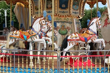 White horses on a colorful carousel.