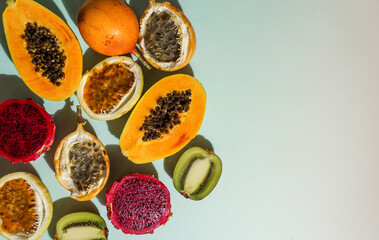 exotic tropical fruits,  passion fruits and dragon fruit, ripe papayas. on a bamboo tray with green leaves, stone background