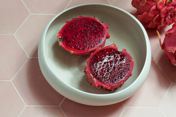 dragon fruit, also known as pitaya, cut open pink magenta-colored flesh with tiny black seeds, tropical fruits