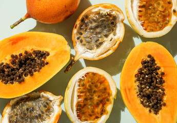 exotic tropical fruits,  passion fruits and dragon fruit, ripe papayas. on a bamboo tray with green leaves, stone background