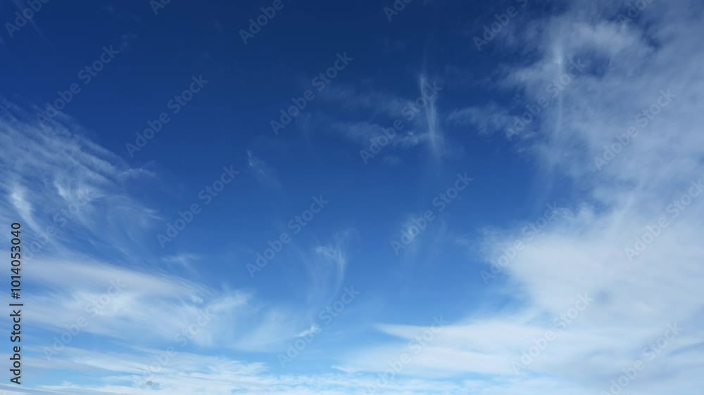 Wall mural time lapse looking up into a bright blue sky with wispy clouds