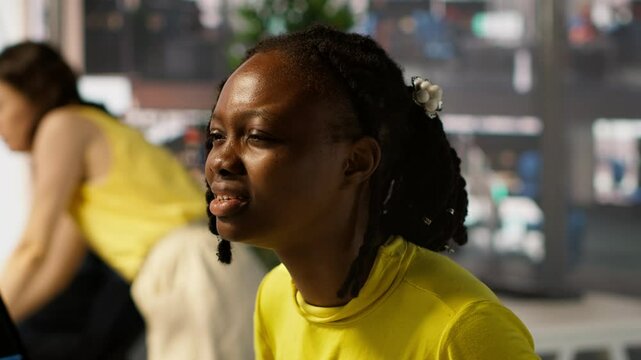 Tired african american programmer having strained eyesight from overworking in office. Close up of woman at work removing eyeglasses to rub eyes, looking at PC screen for too long, camera A