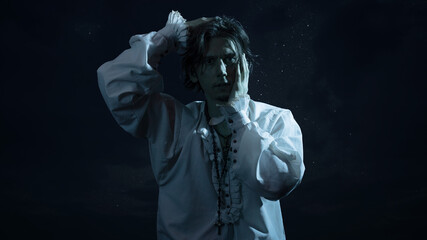 The tragic hero in a white vintage blouse experiences confusion and horror, a portrait in the...