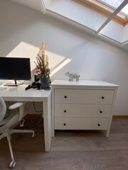 Interior minimalist home office setup with white furniture and natural light. Space exudes simplicity and calm, perfect for productive and focused work