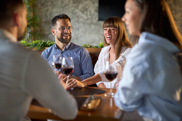 Happy business colleagues communicating while enjoying in their lunch in a restaurant.