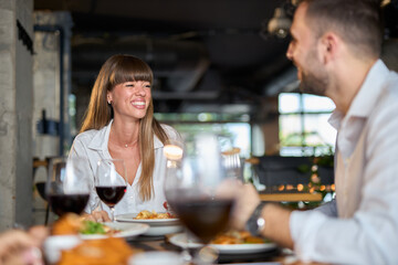 Happy business couple talking on a lunch in restaurant. 