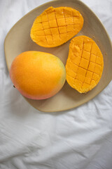 ripe juicy yellow mango on a plate, breakfast in bed