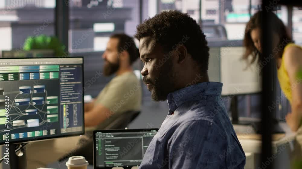 Poster programmer waiting for coworker to come help him fix applications issues, dealing with databases and