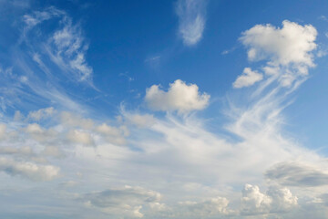 Fototapeta premium The sky is blue with a few clouds scattered throughout. The clouds are white and fluffy, giving the sky a peaceful and serene appearance