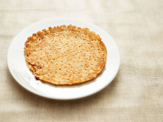 Round pancake or crepes on big plate and simple table cloth. Popular multi national dish.