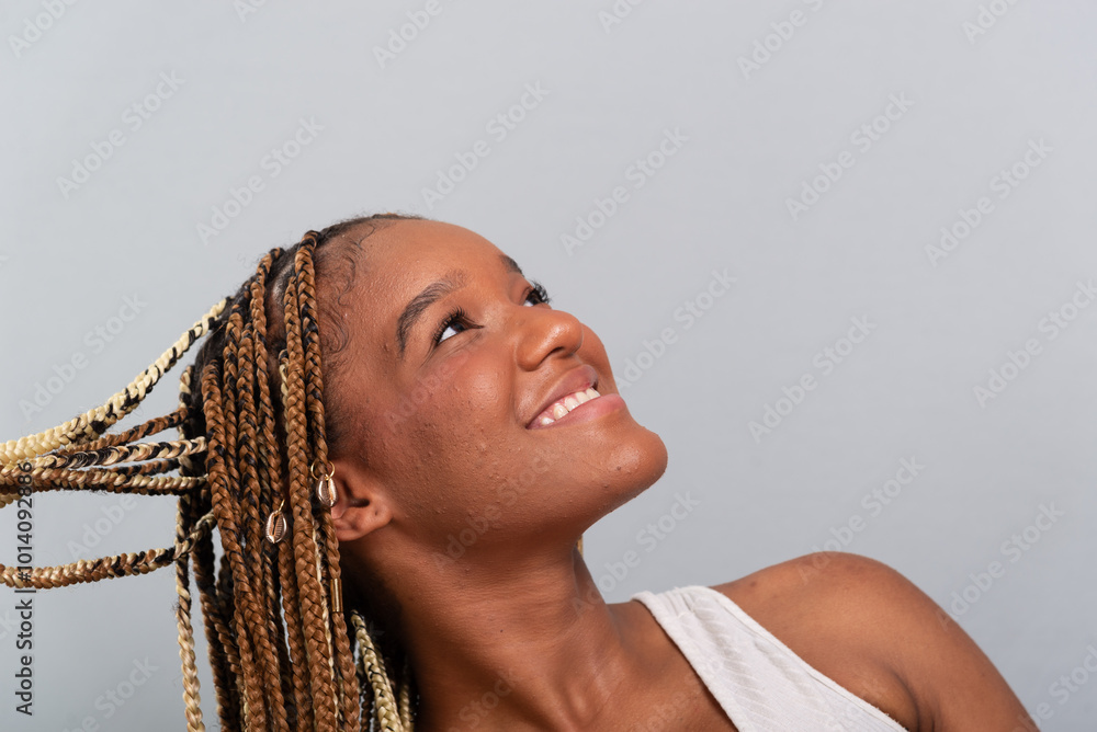 Wall mural beautiful brunette woman with braids in her hair, sitting on the studio floor leaning on a wooden st