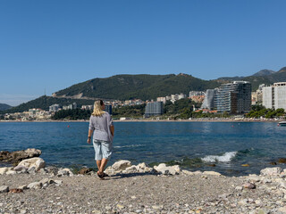 A woman stands and looks at the sea on the shore of the Adriatic Sea