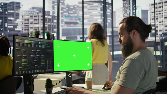 Man working with machine learning tech on green screen computer, advancing AI innovating autonomous systems, close up. Zoom in on mockup PC monitor used by IT expert in office, camera B
