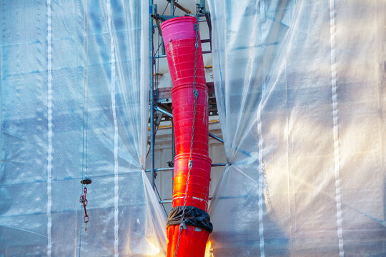 Waste material chutes on construction site. Shot of a conveyor of rubble in the building under renovation