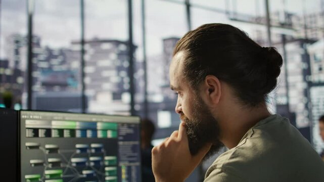 System administrator working with machine learning artificial intelligence critical to autonomous systems. Close up of man transforming data into predictive models, camera B