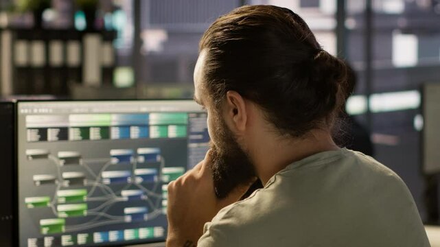 System administrator working with machine learning artificial intelligence critical to autonomous systems. Close up of man transforming data into predictive models, camera A
