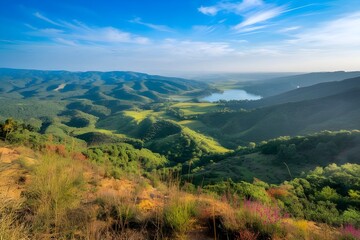 Obraz premium Expansive Scenic Landscape of Rolling Green Hills, a Calm Lake, and Lush Valley Bathed in Golden Sunlight