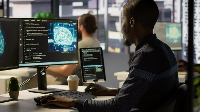 Admin creating AI machine learning models that can process and analyze data to improve decision making processes, looking at PC. Man programming in office using artificial intelligence tech, camera A