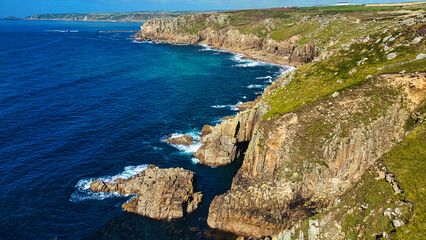 Fototapeta premium Rugged Coastal Cliffs Overlooking Clear Blue Waters in Cornwall, UK