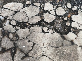 Obraz premium Cracked weathered concrete surface with visible crevices and texture details
