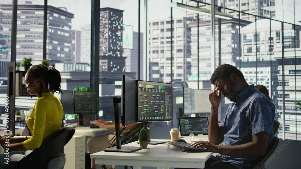 Aufkleber system administrator in office yawning during shift, feeling tired while looking at software interfa