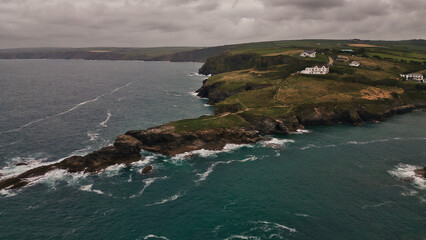 Coastal Cliffs and Ocean Waves under Cloudy Sky in Tintagel, Cornwall, UK