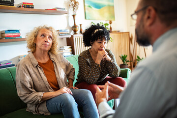 Lesbian couple talking to therapist about their problems at home