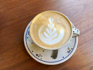 Delicate Latte Art in a Ceramic Cup on Wooden Table