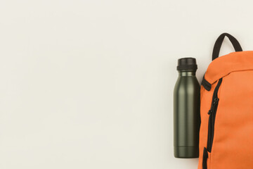 A backpack and a water bottle are on a white background