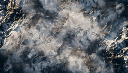 Abstract aerial view of rocky terrain with cloud-like textures, creating a dramatic high-contrast landscape effect.