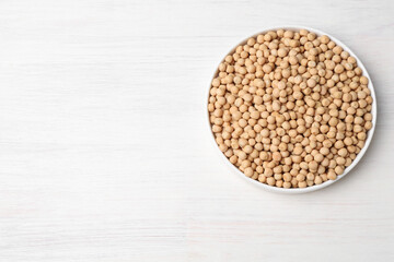 Dried peas on light wooden table, top view. Space for text