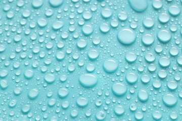 Water drops on turquoise background, above view