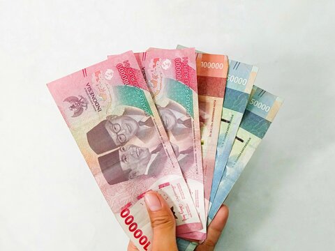 a girl hand holding indonesia money isolated on white background. rupiah money