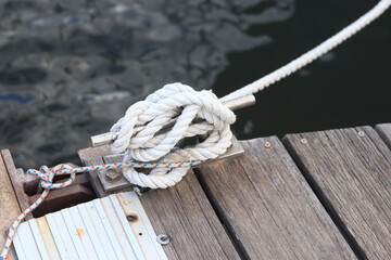 Mooring post, a mooring knot on a yacht pier. The yacht's mooring ropes are attached to the knecht. Knecht on the deck on the pier for fastening ropes. Knecht for mooring and fastening ropes